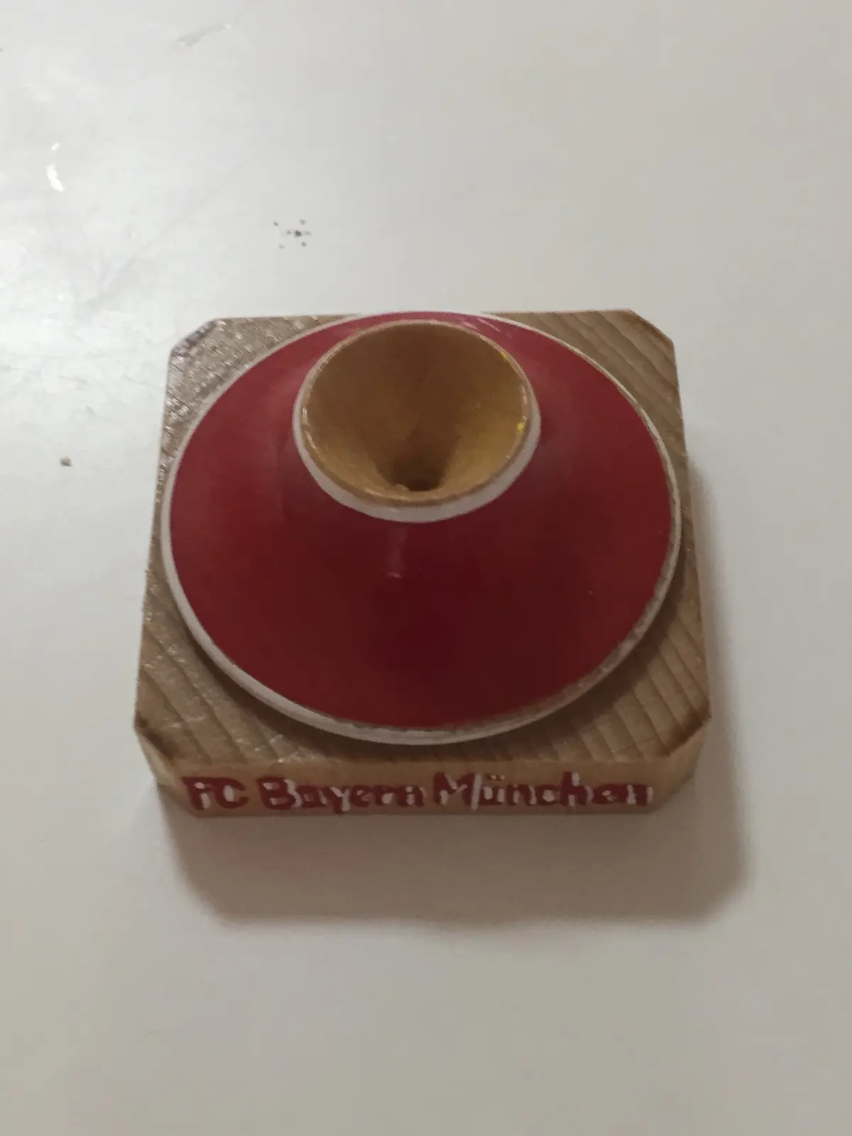 סביבון מצויר  איש עם טבעת משגר  וחוט בתחתית כתוב "FC Bayern München"