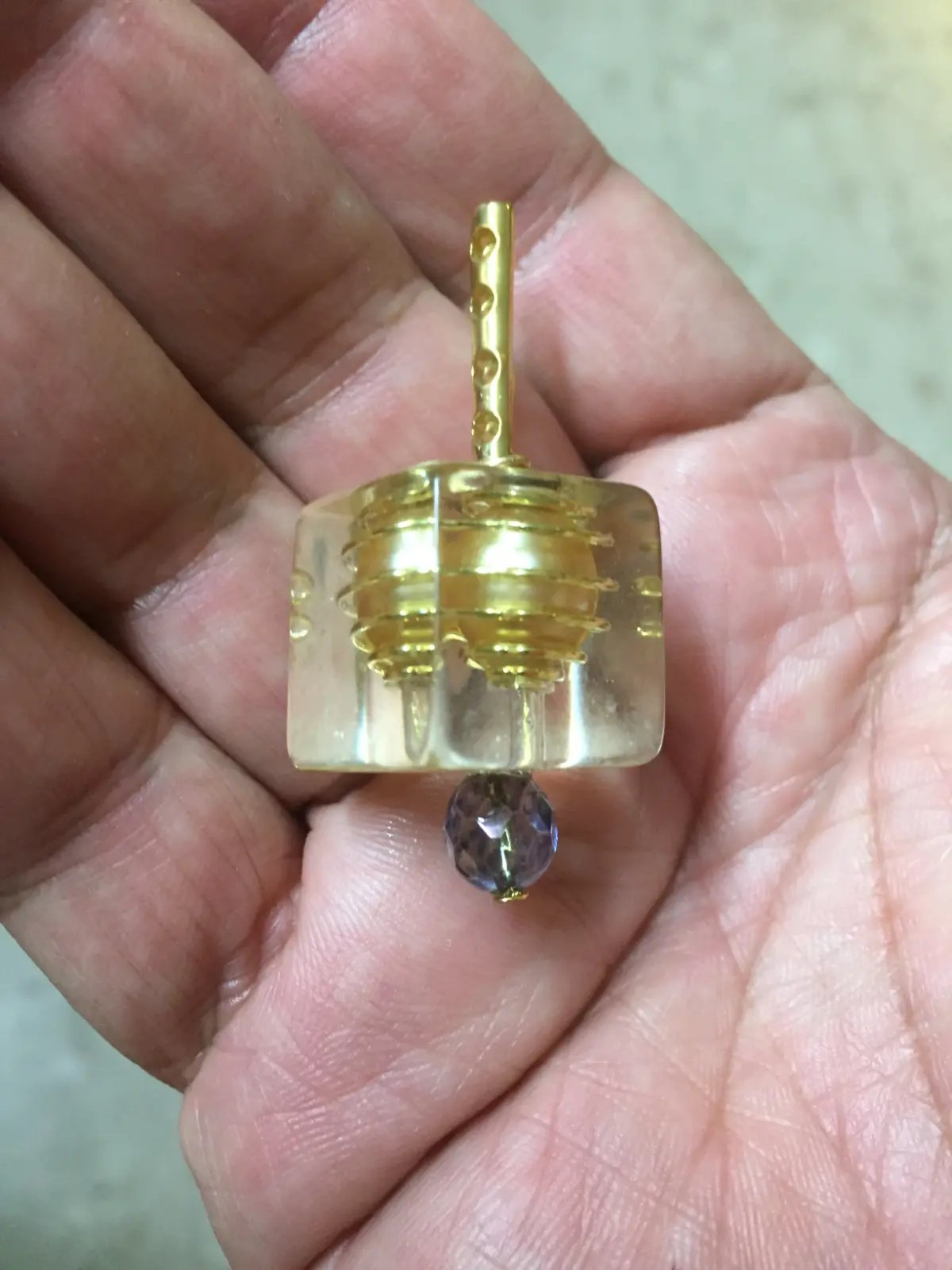 סביבון ריבועי שקוף עם חרוז  ירוק בתוכו